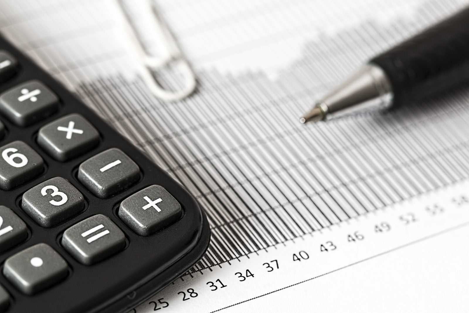 Calculator and pen on a financial statement, preparing a production company tax return and Producer Offset claim